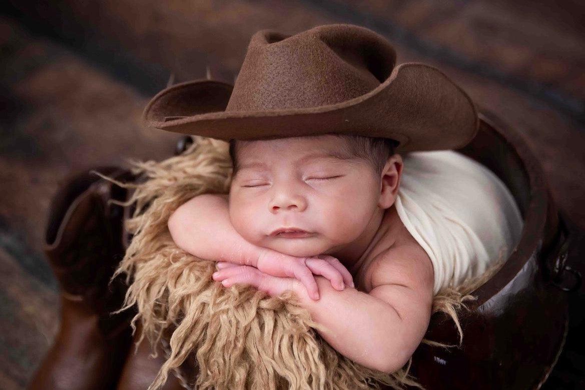 Infant boy deals cowboy hat